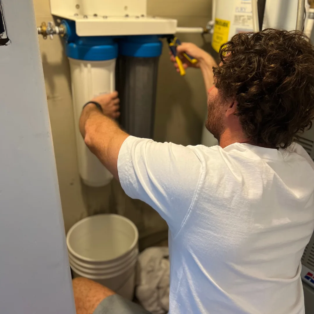 plumber working on a water softener for maintenance