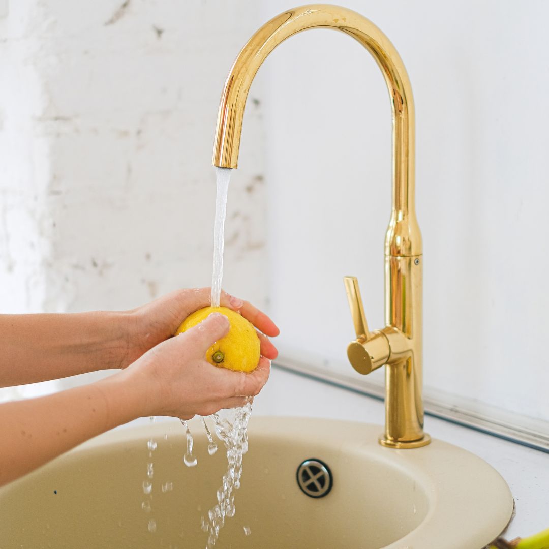 person washing a lemon in a sink