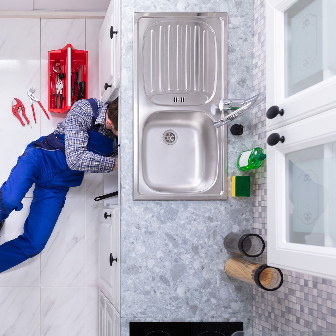 plumber working under sink