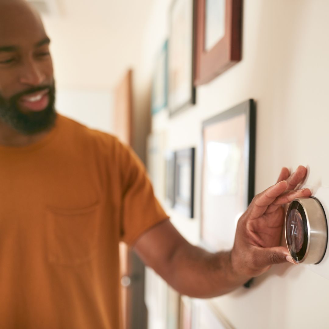 person adjusting thermostat