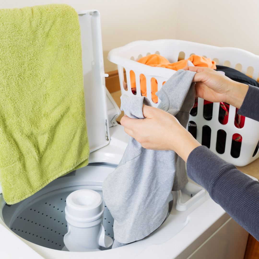 person putting laundry in a washing machine