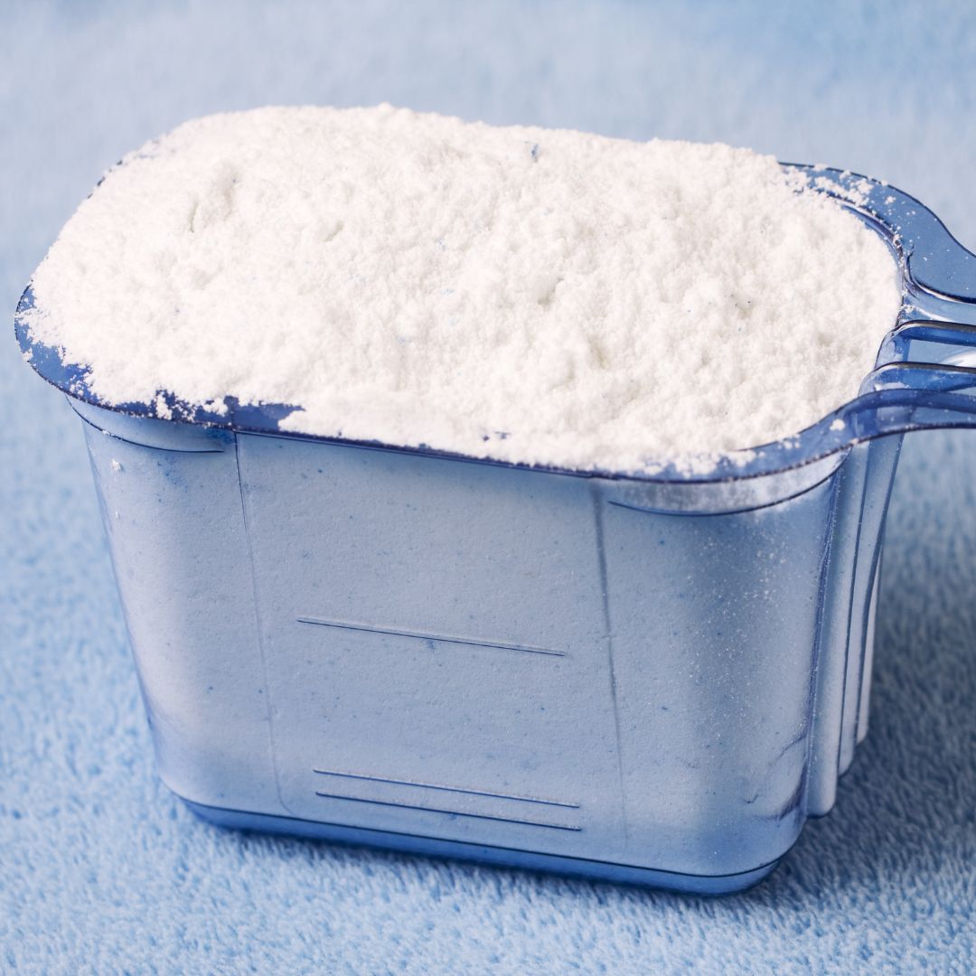 scoop full of powdered laundry detergent