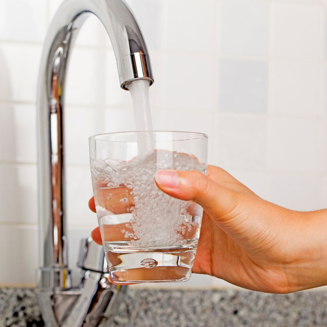 water from a faucet pouring into a glass