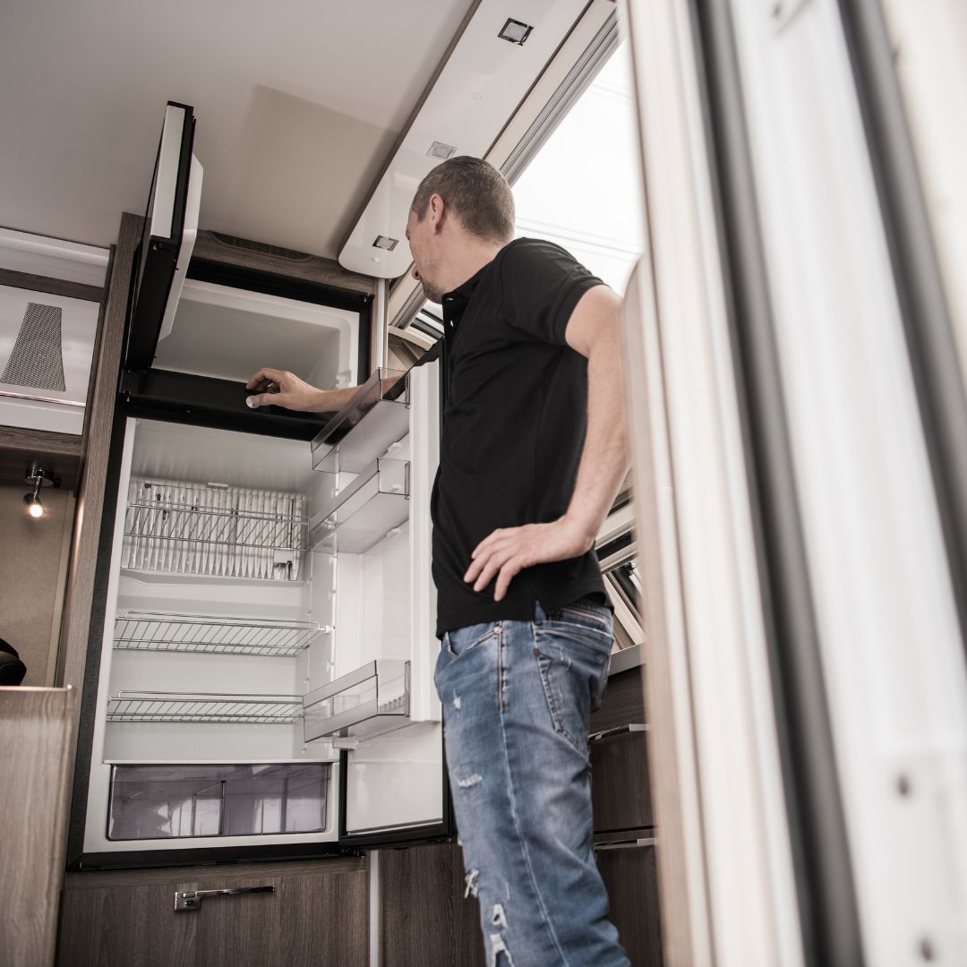man looking at rv fridge