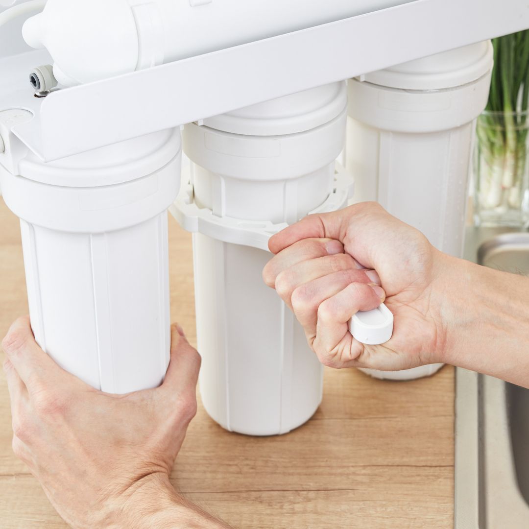 plumber installing water filter cartridge