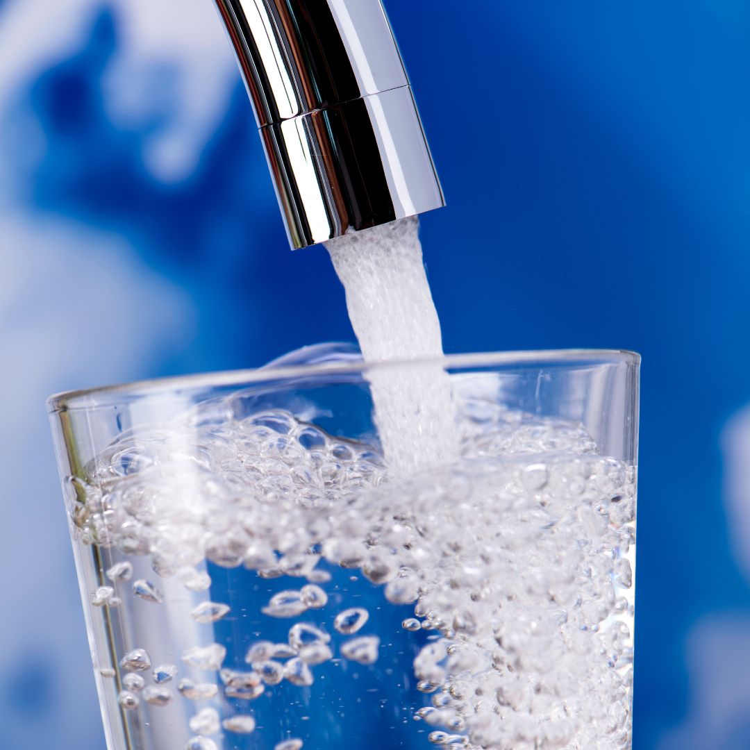 pour clean water from faucet into glass