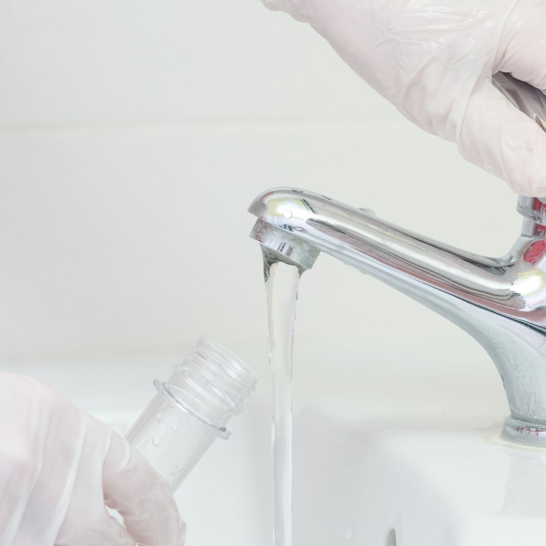 Filling a test tube with water from a sink faucet