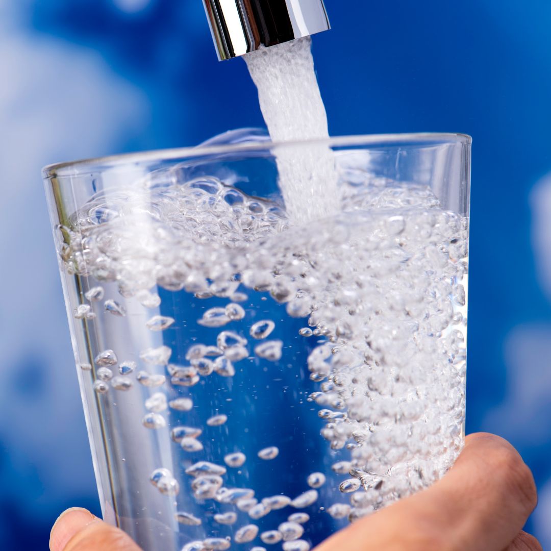 sink faucet filling a glass with water